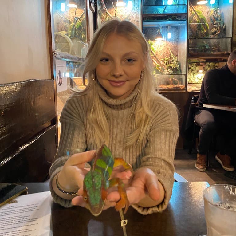 Wiktoria Betlejewska, current Alumni Engagement Intern holding a gecko