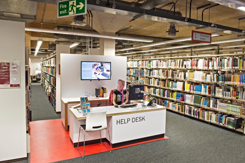 Help desk in the library, with book shelves behind