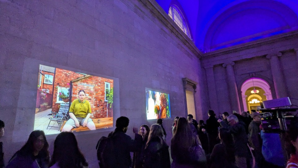 Student photography projected onto a stone wall in the Tate Britain gallery