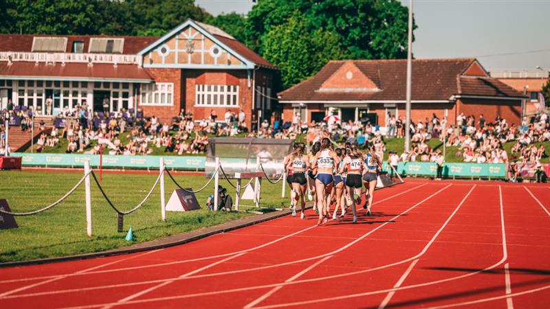 A group of athletes running on an outdoor track.