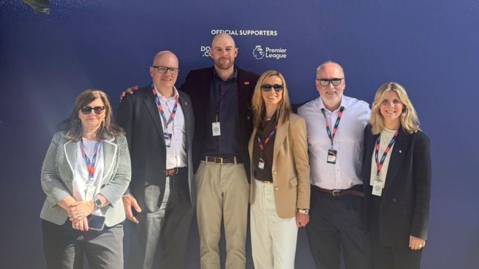 Six people including Professor Nick Jennings and Professor Jo Maher standing together wearing lanyards at the Greater Together event.