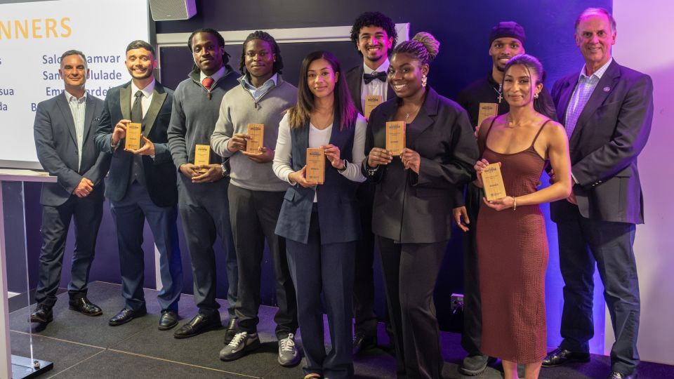 A group of students holding trophies.