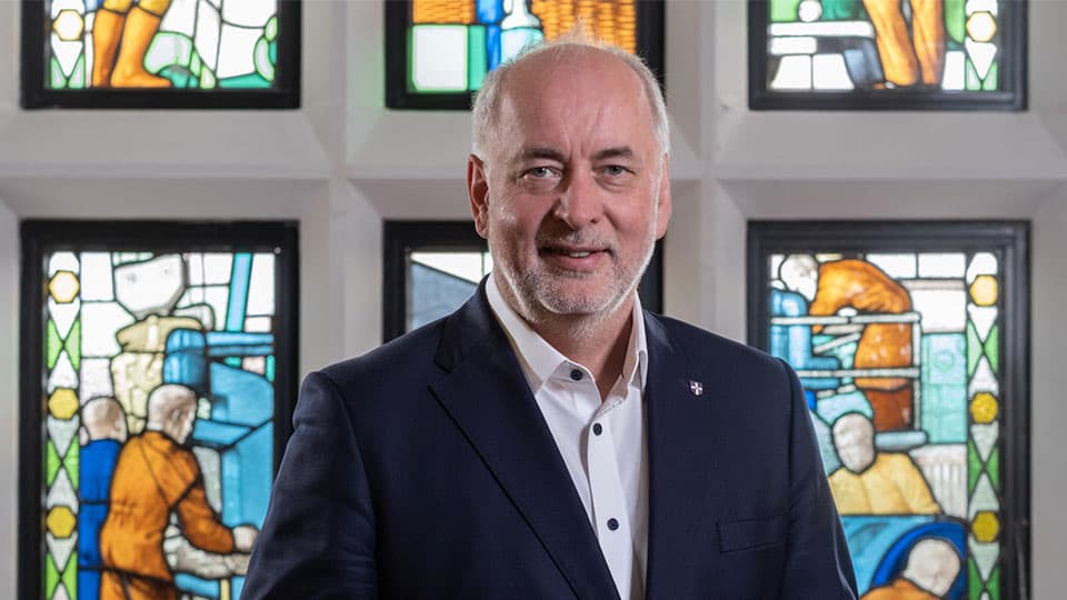 Vice-Chancellor Nick Jennings in front of stained glass windows