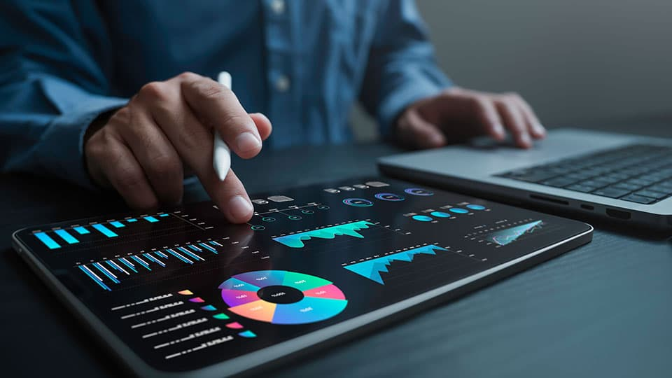 Person interacts with digital tablets displaying colourful pie charts and graphs