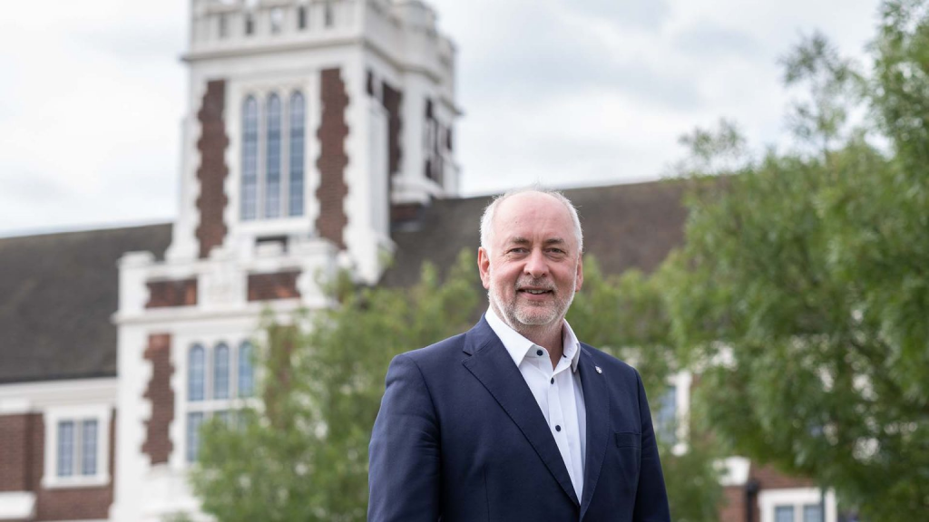 Vice-Chancellor Professor Nick Jennings smiles in front of Hazlerigg building on the Loughborough campus