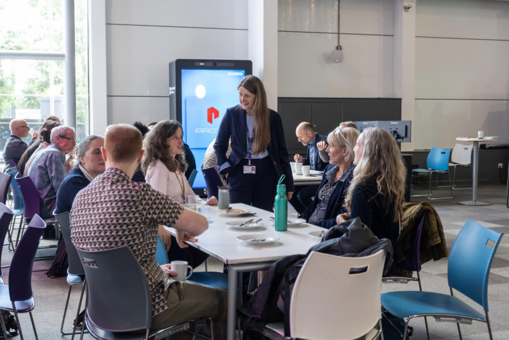 Researchers talk around a table at an event 